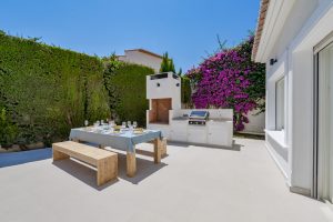 Villa en Benissa - jardín con barbacoa y mesa con bancos