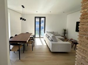Vivienda en Gandía -vista completa del salón con mesa de comedor y sofa